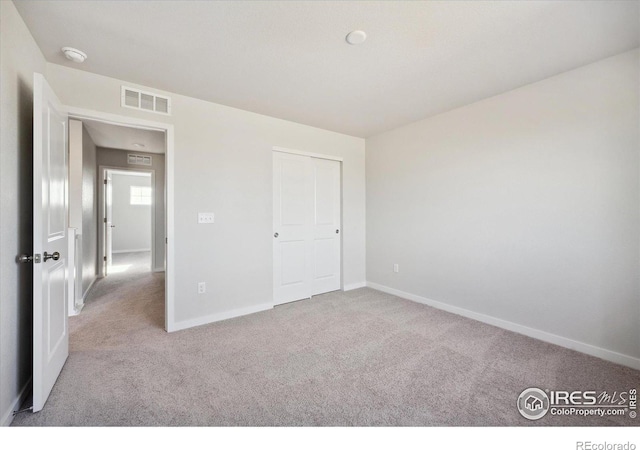 unfurnished bedroom featuring light carpet