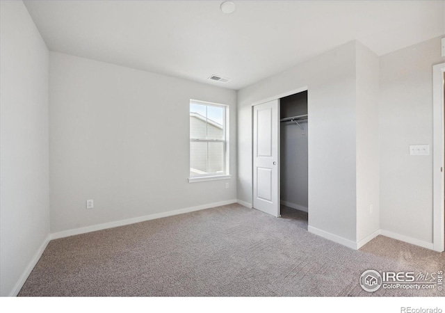 unfurnished bedroom with light carpet and a closet