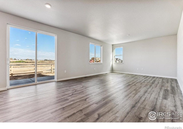 unfurnished room with wood-type flooring and a textured ceiling