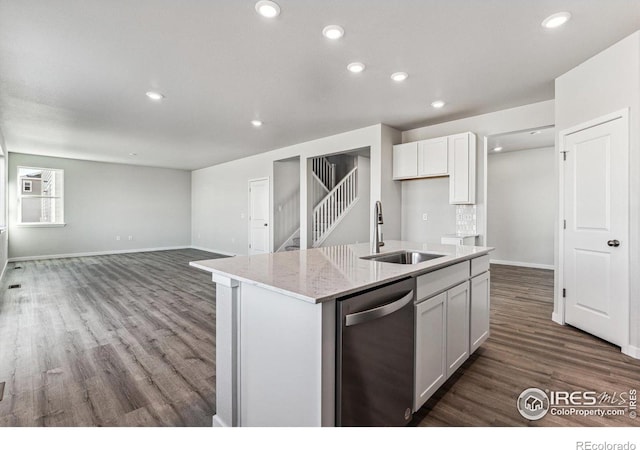 kitchen with wood-type flooring, sink, an island with sink, stainless steel dishwasher, and white cabinets