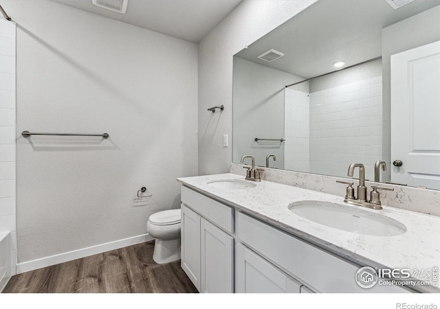 bathroom with vanity, hardwood / wood-style floors, a shower, and toilet