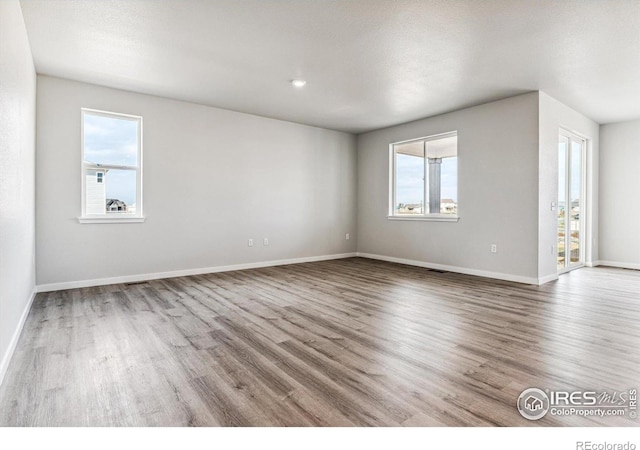 spare room featuring a textured ceiling and wood-type flooring