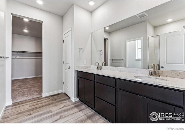 bathroom featuring vanity, hardwood / wood-style floors, and a shower with door