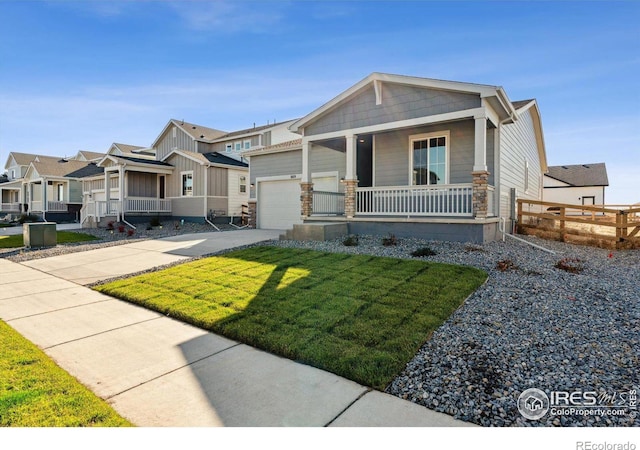 view of front of house with a porch, a front yard, and a garage