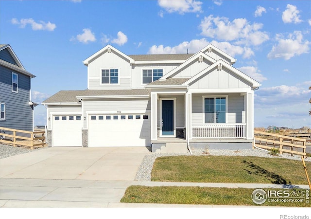 view of front of house featuring a front yard, a porch, and a garage