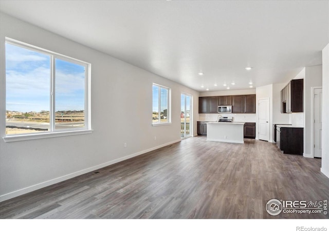 unfurnished living room featuring sink and dark wood-type flooring