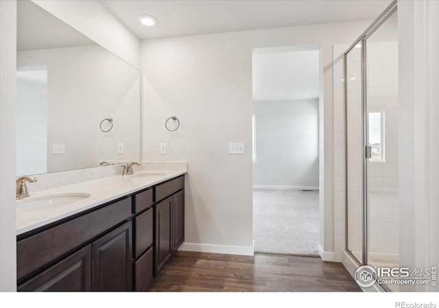 bathroom with hardwood / wood-style floors, vanity, and walk in shower