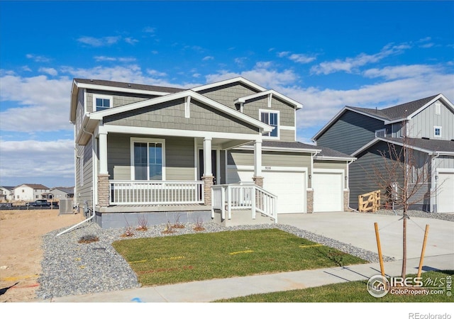 craftsman inspired home featuring covered porch, a front yard, and a garage