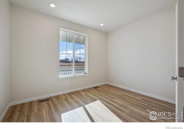 unfurnished room with wood-type flooring