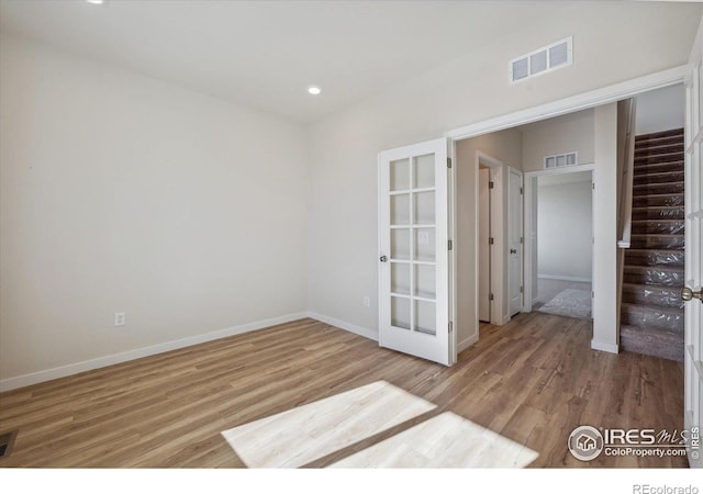 spare room with french doors and light wood-type flooring