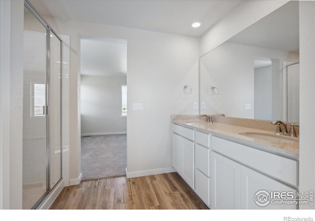 bathroom featuring hardwood / wood-style floors, vanity, a healthy amount of sunlight, and walk in shower