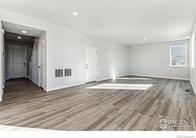 unfurnished room featuring baseboards, recessed lighting, wood finished floors, and visible vents