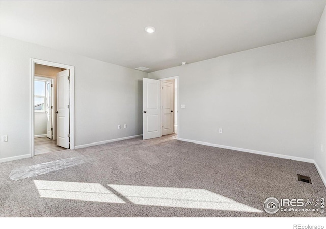 unfurnished bedroom featuring baseboards, recessed lighting, carpet flooring, and visible vents