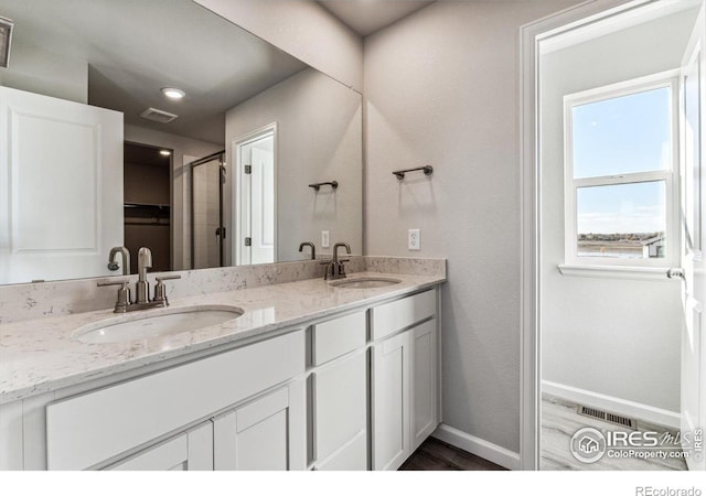 bathroom with a sink, wood finished floors, and visible vents