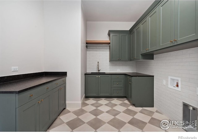 kitchen featuring tasteful backsplash, sink, and green cabinetry