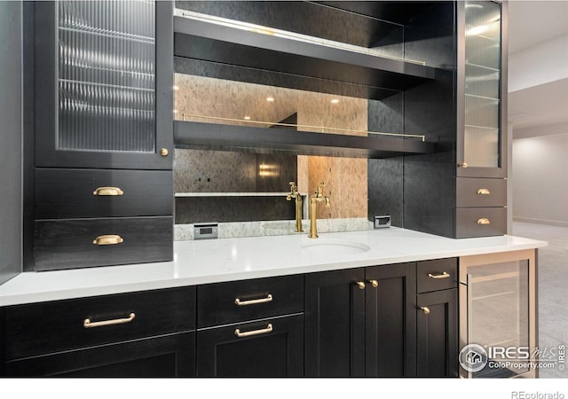 bar featuring backsplash, wine cooler, and sink