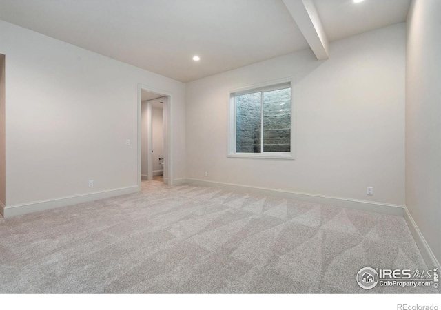 carpeted spare room with beamed ceiling