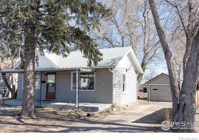 bungalow-style house with a porch, an outbuilding, and a garage