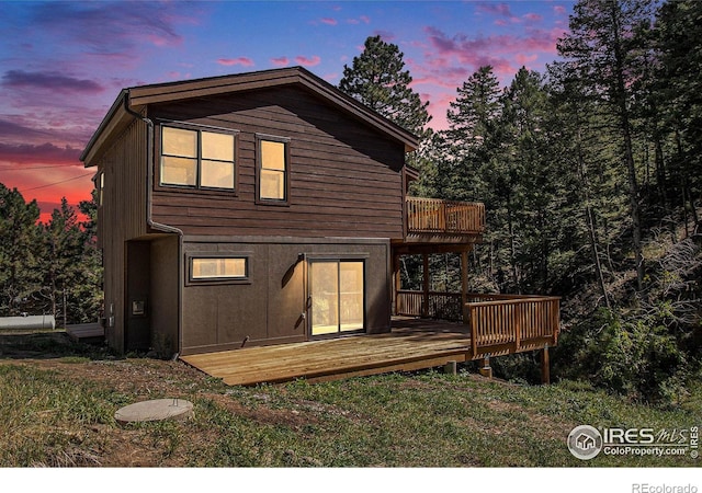 back house at dusk with a deck