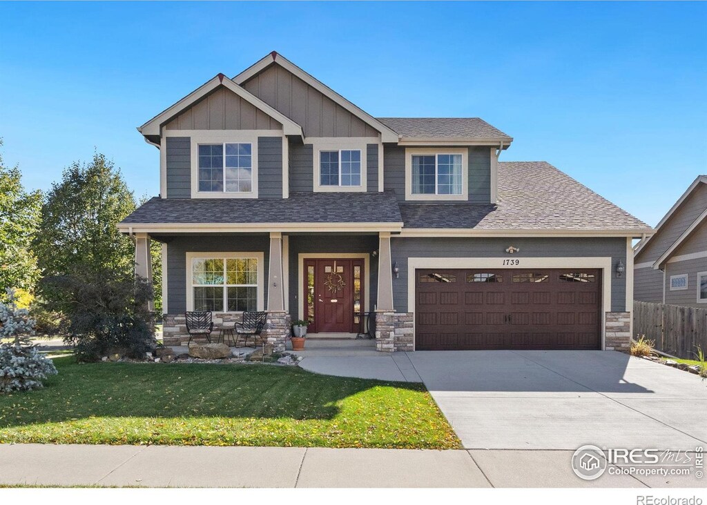 craftsman-style house featuring covered porch, a garage, and a front lawn