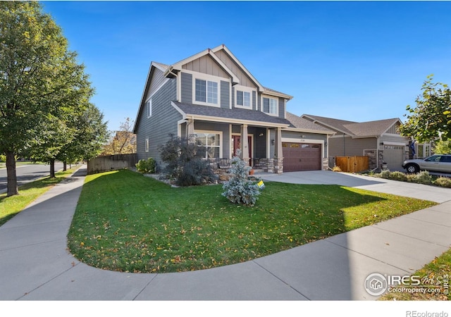 view of front of house with covered porch, a garage, and a front lawn