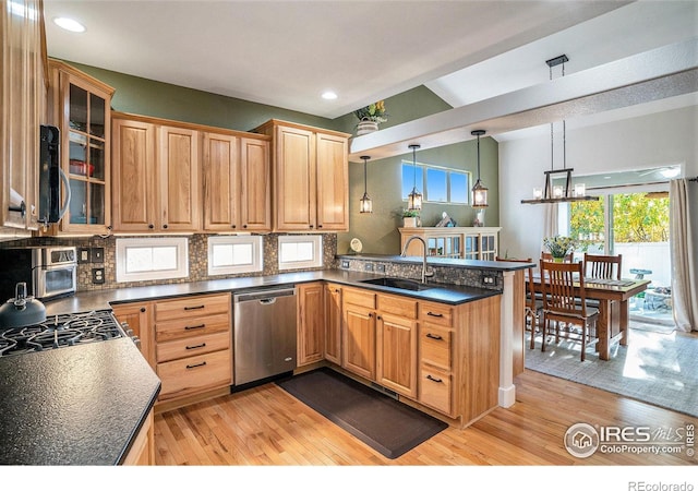 kitchen with dishwasher, decorative light fixtures, sink, and light wood-type flooring