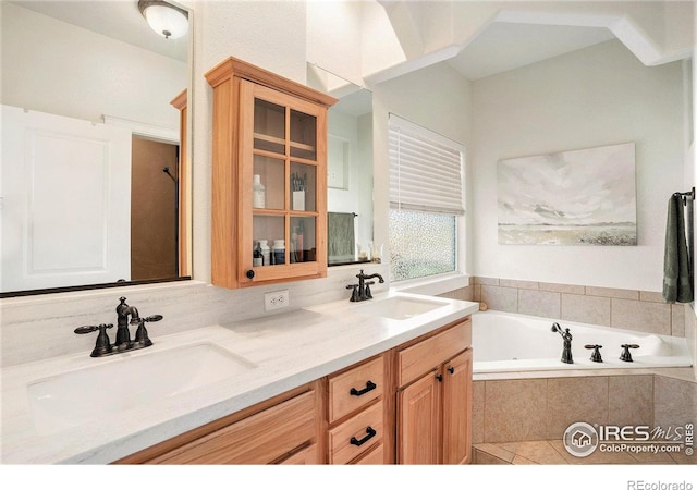 bathroom featuring vanity and tiled bath