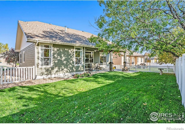 back of property with a yard and a patio area