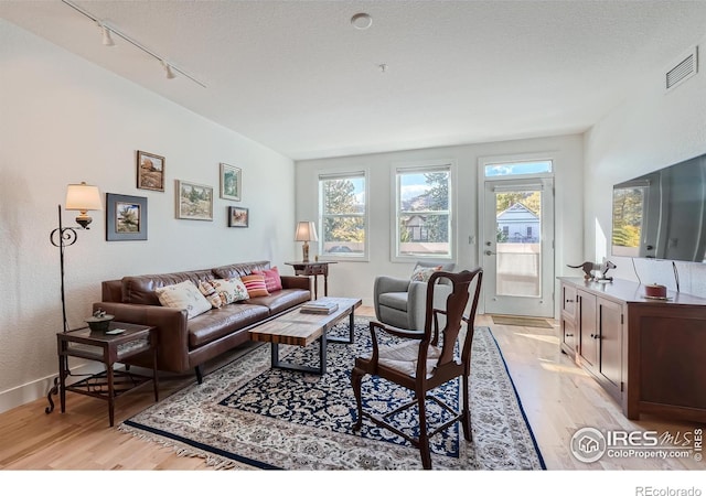 living room featuring light hardwood / wood-style floors and a textured ceiling