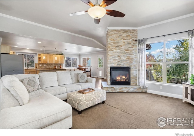 carpeted living room with crown molding, a fireplace, and ceiling fan