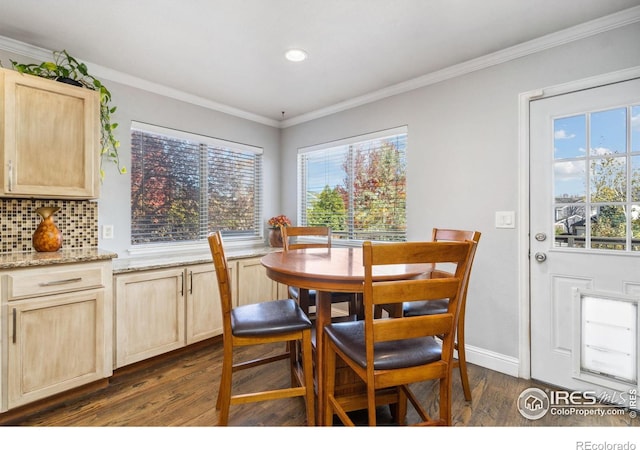 dining area featuring dark hardwood / wood-style flooring, crown molding, and plenty of natural light