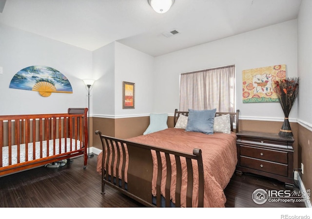 bedroom with dark hardwood / wood-style floors