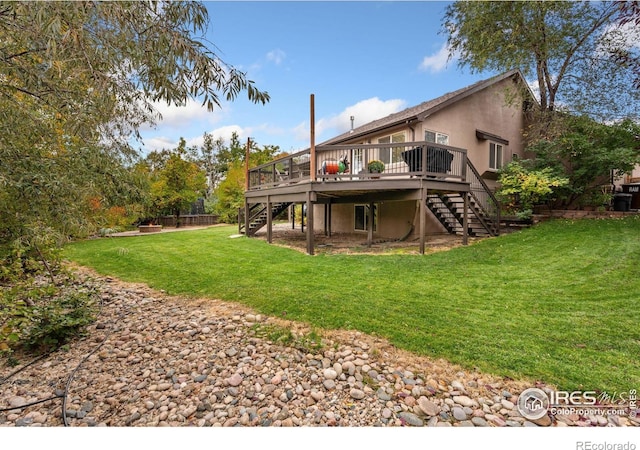 rear view of house with a wooden deck and a lawn