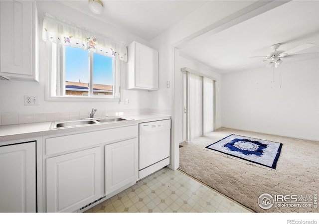 kitchen featuring dishwasher, sink, white cabinetry, ceiling fan, and light colored carpet