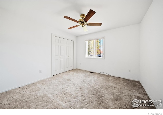 unfurnished bedroom with a closet, ceiling fan, and carpet floors