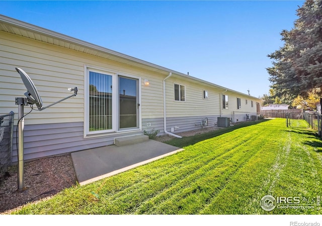 back of property with a patio area, a lawn, and central AC unit