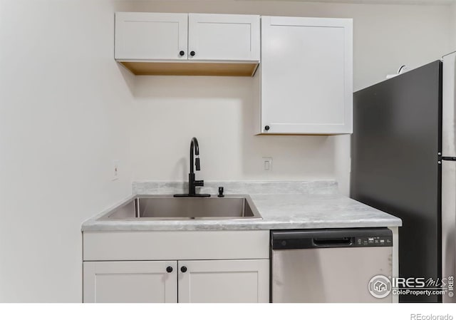 kitchen featuring appliances with stainless steel finishes, sink, and white cabinets