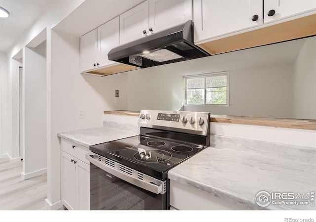 kitchen featuring light hardwood / wood-style floors, stainless steel electric stove, and white cabinets