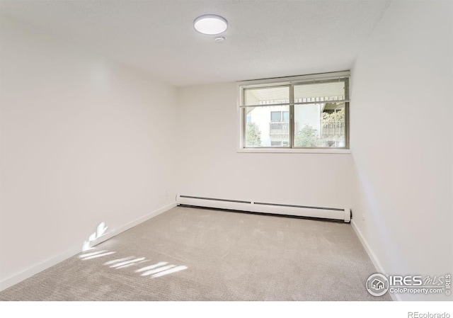 carpeted empty room with a baseboard radiator