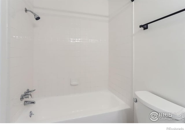 bathroom featuring toilet and tiled shower / bath