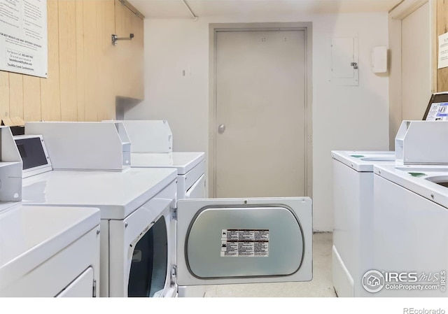 clothes washing area featuring electric panel and washing machine and clothes dryer