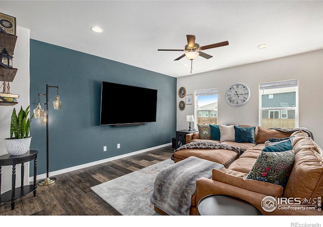 living room with dark wood-type flooring and ceiling fan