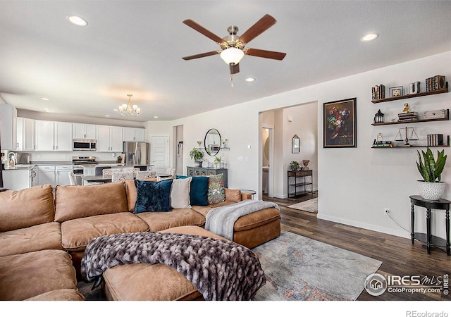 living room with sink, dark hardwood / wood-style floors, and ceiling fan with notable chandelier