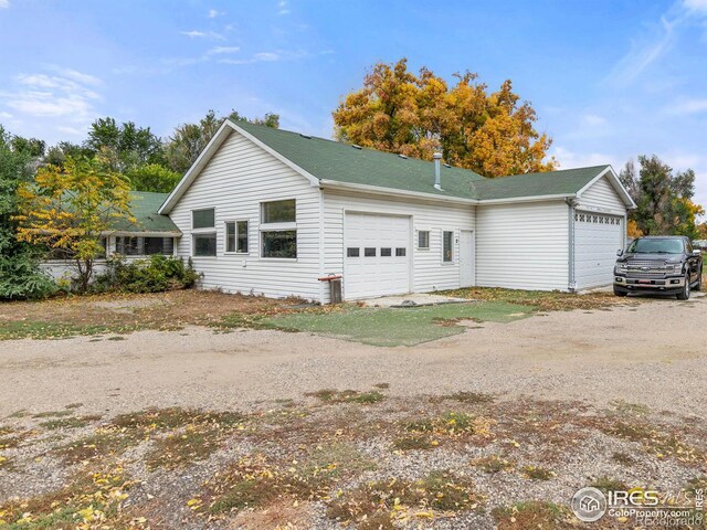 1601 E 1st St, Loveland, CO 80537 - view of side of property with an attached garage and roof with shingles