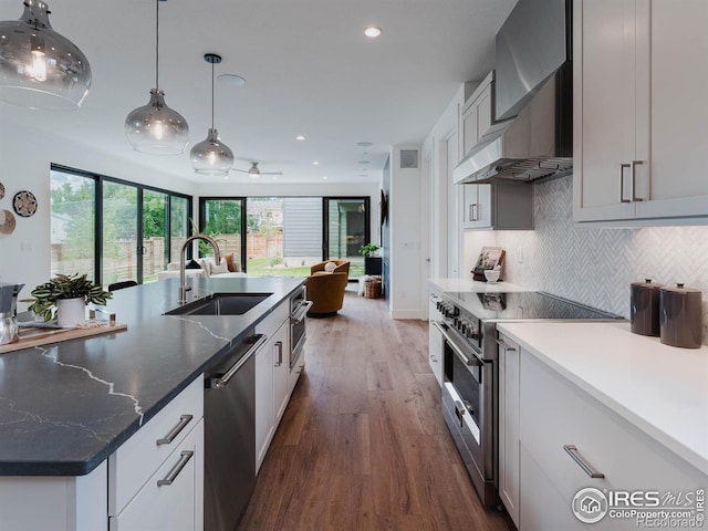 kitchen with white cabinets, hanging light fixtures, dark hardwood / wood-style flooring, appliances with stainless steel finishes, and sink