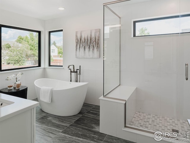 bathroom featuring vanity, a healthy amount of sunlight, and independent shower and bath