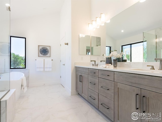 bathroom with vanity, a bathtub, and high vaulted ceiling