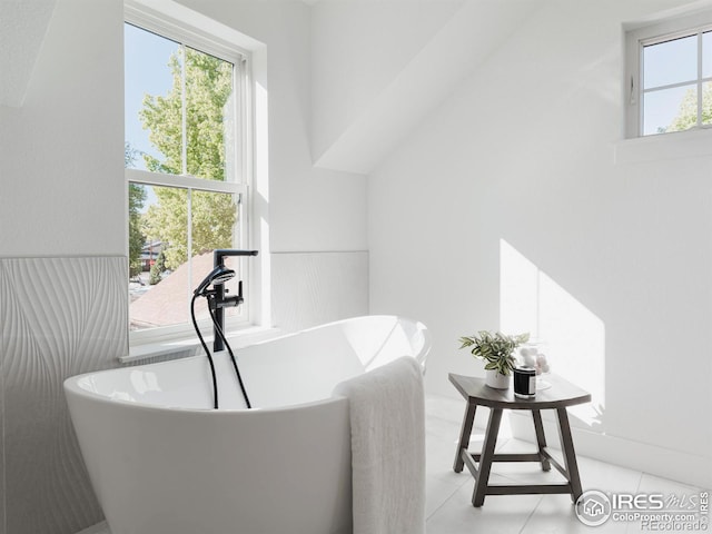 bathroom with tile patterned floors and a washtub