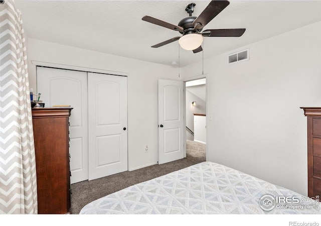 carpeted bedroom featuring a textured ceiling, a closet, and ceiling fan