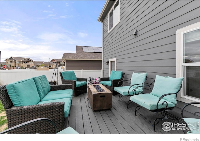 deck featuring an outdoor living space with a fire pit